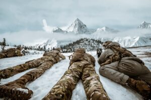 A group of soldiers laying in the snow.