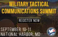 Military tactical communications equipment displayed on table.