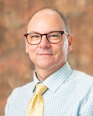 A man wearing glasses and a checkered shirt.