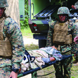 A group of marines carrying a patient on a stretcher.