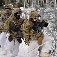 A group of soldiers are running through the snow.